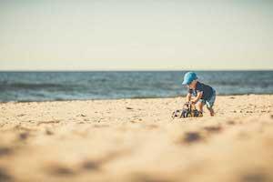 Boy Playing In The Beach